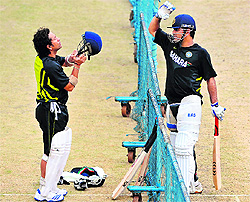 Sachin Tendulkar (L) and MS Dhoni talk during a practice session in Bangalore on Thursday
