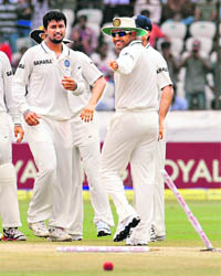 Virender Sehwag points out the uprooted stumps to Ojha. 