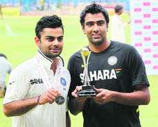 Man of the Match Virat Kohli and Man of the Series R Ashwin pose after India won the match and the series against New Zealand in Bangalore on Monday. 