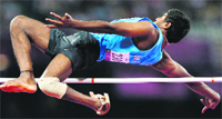 Silver medallist Girisha Nagarajegowda in action in the men�s high jump F42 classification final (above) and walking after competing at the 2012 Paralympics Games in London. � AP