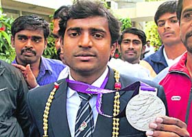 London Paralympics high jump silver medallist Girisha Hosanagara Nagarajegowda shows his medal on his arrival in Bangalore on Wednesday