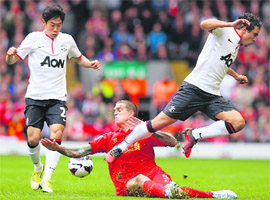 Liverpool�s Daniel Agger (C) is challenged by Manchester United�s Shinji Kagawa and Rafael during their English Premier League match in Liverpool on Sunday. 