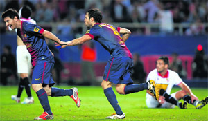 Barcelona's Cesc Fabregas is congratulated by Lionel Messi after scoring against Sevilla in Seville on Saturday.