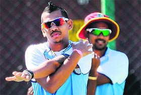 Sunil Narine and Denesh Ramdin of the West Indies stretch during a training session in Colombo on Saturday