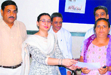 Gurgaon Chief Judicial Magistrate-cum-DLSA Secretary Narinder Kaur presents a certificate of appreciation to a volunteer for taking good care of mentally challenged persons at Gurgaon on World Mental Health Day.