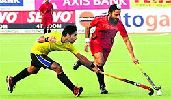 Rajpal Singh of Punjab Police reaching out for the ball, as does an Indian Oil player, during an Indian Oil Surjit Singh Memorial Hockey Tournament match in Jalandhar on Wednesday