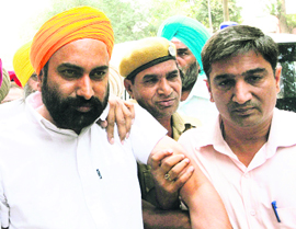 Sarbhdyal Singh (L) being brought to a court in Amritsar. 