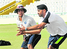 Punjab skipper Harbhajan Singh and Mandeep Singh (L) during a catching session at the PCA Stadium, Mohali, on Thursday.