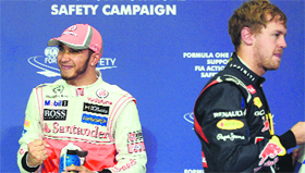 McLaren Mercedes� Lewis Hamilton (L) celebrates beside Red Bull Racing�s Sebastian Vettel after the qualifying session at the Yas Marina circuit in Abu Dhabi on Saturday.
