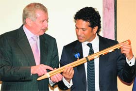 Simon Crean (L), Australian Minister for Regional Australia, Regional Development and Local Government, shows a stump decorated by an aboriginal artist to Sachin Tendulkar in Mumbai