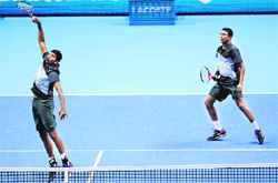 Rohan Bopanna smashes as Mahesh Bhupathi watches during their win over Robert Lindstedt and Horia Tecau. � AFP 