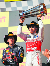 McLaren�s Lewis Hamilton trumps Red Bull�s Sebastian Vettel to lift the U.S. Grand Prix trophy on Monday; Hamilton (top right) sports a Cowboy hat with a grin at the podium.