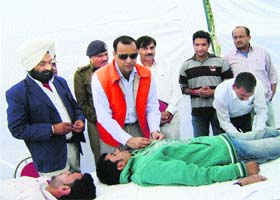 District police chief Rakesh Kumar Arya (second from left) sticks the Red Cross badge to a blood donor at a voluntary blood donation camp organised by the district police in collaboration with the Road Safety Organisation, Kurukshetra