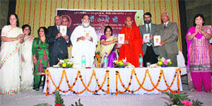 Joonapeethadheeshwar Acharya Mahamandaleshwar Swami Avdheshanand Giri (fourth from right) and Mahamandaleshwar Gita Manishi Swami Gyananand Ji Maharaj (fifth from left) release the poetry book �Maan Thandi Chhan�, written by Sumedha Kataria (sixth from left), Additional Deputy Commissioner, Kurukshetra, at a function at RK Sadan, Kurukshetra University. 