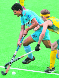 India�s Birendra Lakra Singh (L) and Matthew Swann of Australia tangle sticks during the second semifinal at the men's Hockey Champions Trophy tournament in Melbourne on Saturday