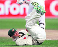 Michael Clarke rolls on the ground after dropping Kumar Sangakkara on the fourth day of their Test match at Bellerive Oval in Hobart, on Monday.