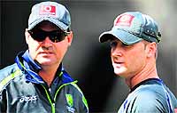 Australian cricket captain Michael Clarke (R) talks with coach Mickey Arthur (L) as Clarke struggles with a hamstring injurybefore Australia takes on Sri Lanka in the second Test match starting at the Melbourne Cricket Ground (MCG) on Tuesday