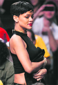 Miami Heat�s LeBron James holds onto a basketball net during a timeout in their NBA game against the Oklahoma City Thunder; Recording artist Rihanna (top) during a game