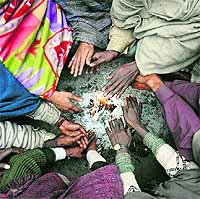 Rickshawpullers sit around fire to keep themselves warm on a chilly morning near Nirmal Kutia in Karnal