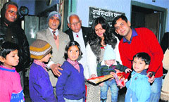 Aditya Dhiman (extreme right) distributes stationery items among students at Government Middle School, Raogarh. Photo: DR Vij