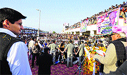 Haryana Chief Minister Bhupinder Singh Hooda addresses a gathering at Jhajjar railway station as his son and Congress MP from Rohtak Deepender Hooda looks on