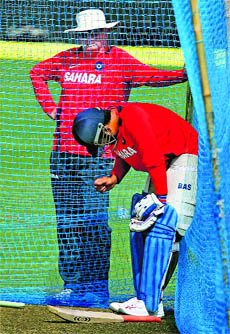 Skipper MS Dhoni nurses a thumb injury during practice as coach Fletcher watches on in Ranchi. 