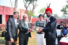 Arvinder Pental (right) region manager, central and south Asia, Frigoglass India, receives a memento during a programme at Chhatera village in Sonepat. 