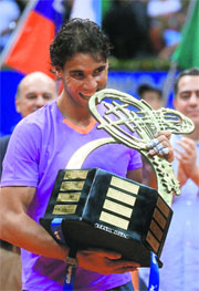 Rafael Nadal gives the Brazil Open trophy his trademark bite after his win on Sunday. 