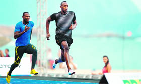 Usain Bolt (right) and his Antiguan training mate Daniel Bailey train on the 150 metre track on Copacabana beach in Rio de Janeiro.