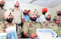 Police officials display fake currency and other material seized from robbers in Rajpura on Thursday. Photo: JS Virdi