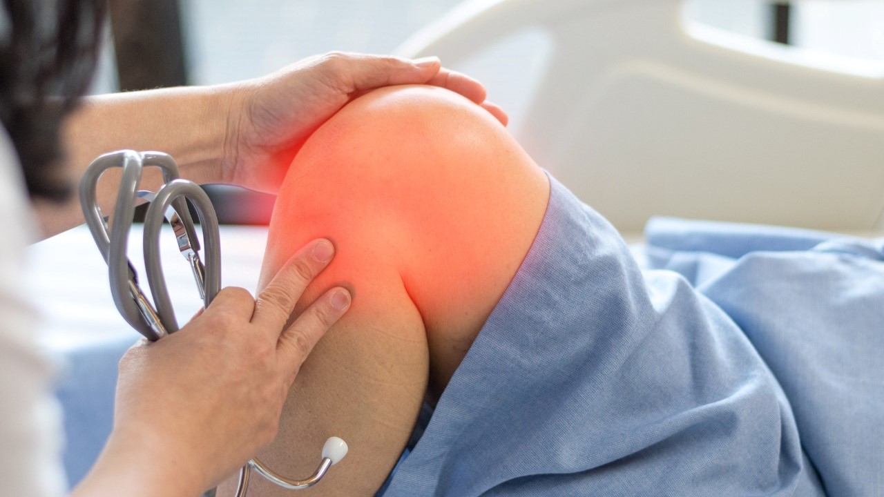 patient with sore red knee and doctor with stethoscope