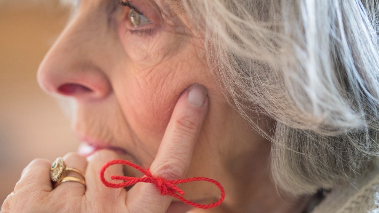 woman wearing a red ribbon to help memory disorder