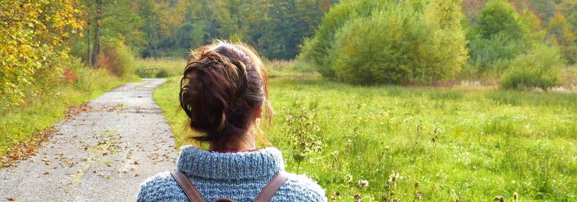 woman gazing at a grass field and a road