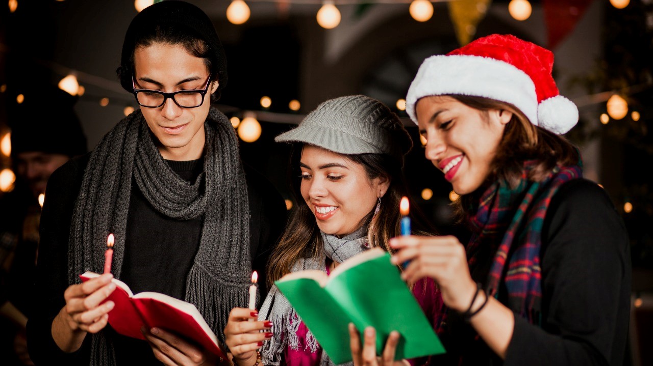 Three people singing carols in a mexican-posada-navideña