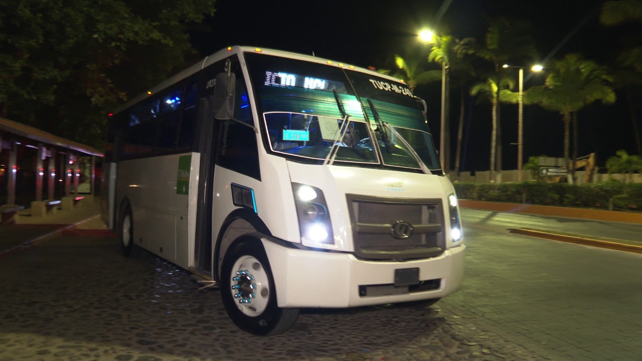 Bus with lights on parked at night