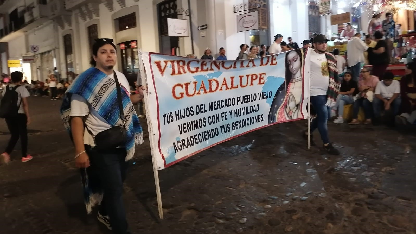 People walking holding a sign on the pilgrimages in Puerto Vallarta