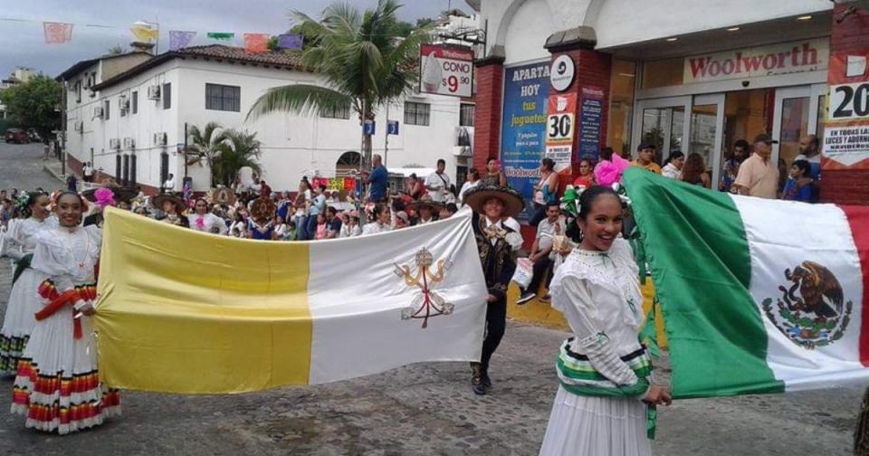 people marching with Vatican and Mexican flags