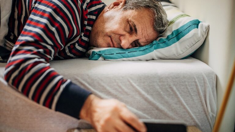 man with sleeping disorders looking at a clock