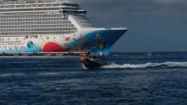 Navy boat in front of a cruise ship