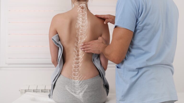 doctor checking a patient's back with spine highlighted