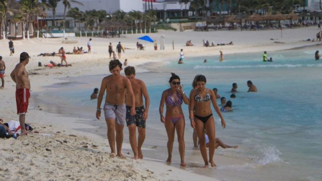 tourists walking on Cancun beach