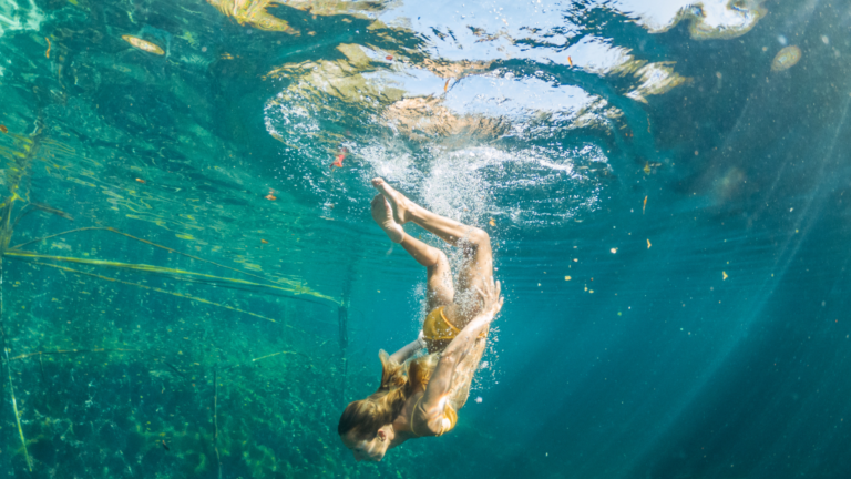 Woman diving in a cenote near Cancun