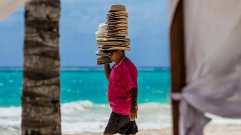 beach vendor wearing a bunch of hats