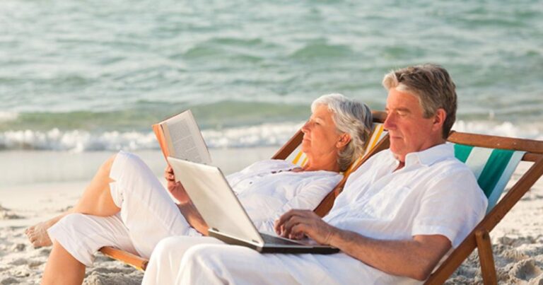Older couple reading on the beach