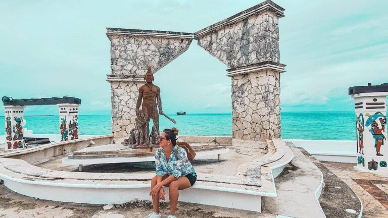 Girl sat at a monument on the Cozumel Malecon