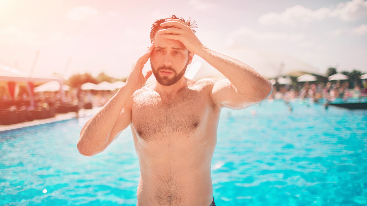 Man by the pool with symptons of a heat stroke.