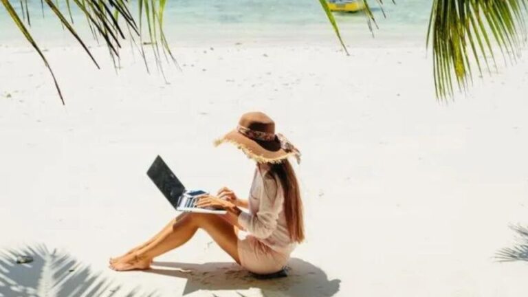 Woman using laptop on the beach