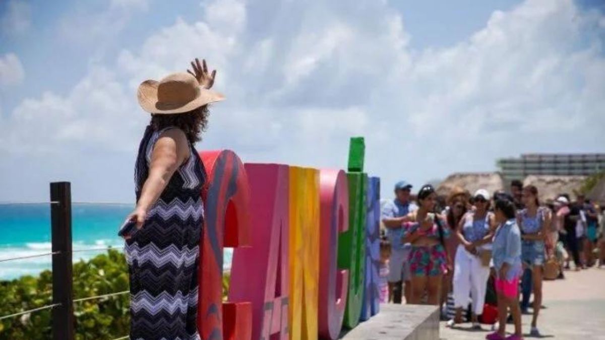 Tourists by the Cancun sign