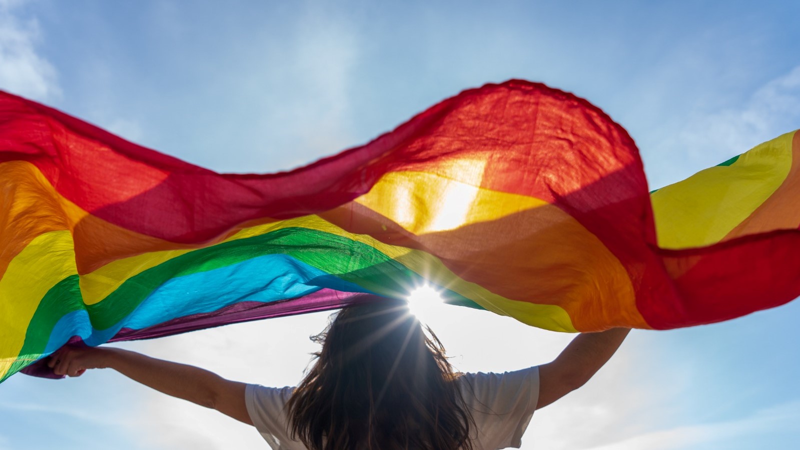 LGBTQ flag waving under the sun