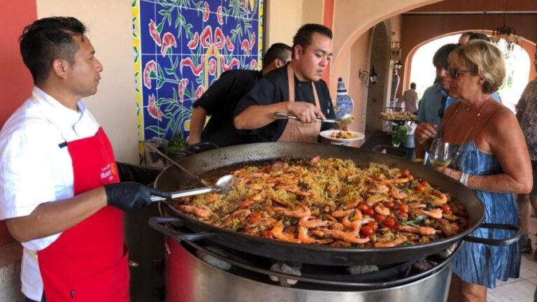 Chefs and diner with a paella dish